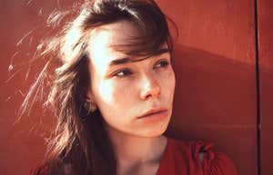 After Years, Happiness Comes Down To These Simple Things Woman with freckles looking off to the side in quiet reflection, appearing thoughtful and emotionally guarded.