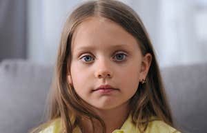 Why Babies & Little Kids Stare At You So Much, According To Science young girl staring with serious face