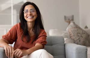 smiling woman sitting on couch at home