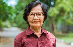 older woman smiling outside saying outdated phrases