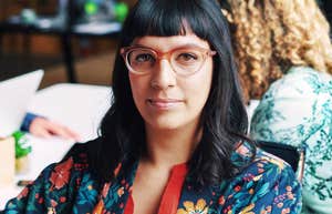 People Who Command Attention When They Speak Practice These Confidence Habits confident professional woman with glasses making direct eye contact in modern workspace, poised expression and calm presence conveying strong communication skills and natural authorit