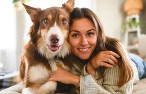 woman laying next to her Australian Shepherd dog