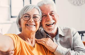 A happy older couple hugging and smiling, illustrating that choosing separate beds or 'sleep divorce' can actually strengthen a relationship and improve comfort in later years.