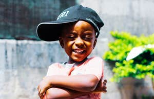 Nineties kid wearing a hat outdoors with a calm, confident expression, illustrating the self-assured traits experts say many 1980s and 1990s kids developed