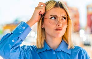 woman scratching her head confused
