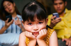 little girl feeling like an outsider in her own family being ignored by parents