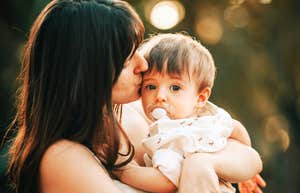 Mother embracing child closely. 