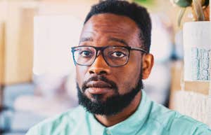 Portrait of a young professional Black man with a thoughtful, serious expression; a visual of the growing number of Americans struggling with insurance premiums and high out-of-pocket costs.