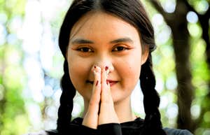 young gen z woman with prayer hands tapping into spirituality