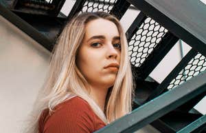 A pensive portrait of a woman staring directly into the camera; illustrating the quiet intensity and analytical mind often associated with the world's most talented and intelligent individuals.