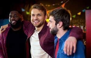 guy friends hugging celebrating bachelor party in bar,
