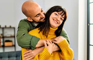 man hugging woman from behind nonverbally showing his love