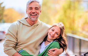 genuinely good parent hugging his daughter outside