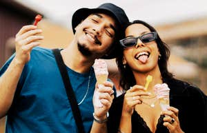 A portrait of a young couple sharing a lighthearted moment with ice cream; illustrating the research-backed concept of being 'on the same wavelength' through mirrored body language and shared emotional resonance.
