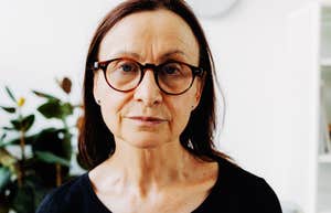 Gen-X female professional focusing intently on the camera through glasses; illustrating Gen-X invisibility' and the frustration of being bypassed for leadership roles despite extensive experience
