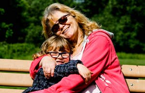 A close-up lifestyle shot showcasing the relationship between a grandmother and her grandchild; illustrating the 'anxiety contagion' concept and the invisible emotional labor required to shield children from generational stress.