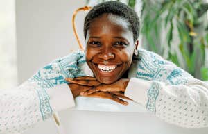good and honest woman smiling from behind couch