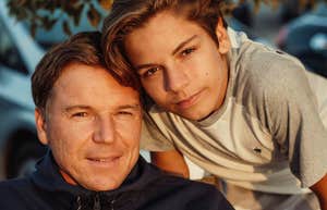 devoted father sitting with his teen son