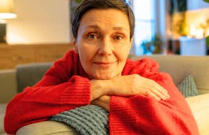 Woman rests her chin on crossed arms, her easy smile reflecting the calm confidence of setting a boundary.