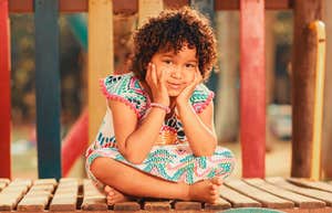 smiling child on the playground sitting 