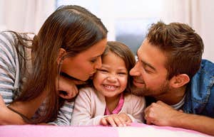 evolved nest parents giving their happy daughter affection