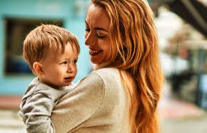 mom carrying toddler son