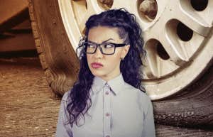 confused woman in front of flat tire