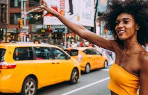 woman in yellow hailing a taxi cab