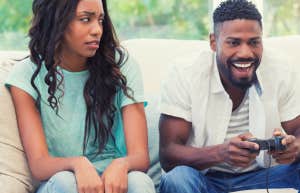 woman annoyed that her husband is ignoring her bid for attention and playing a video game