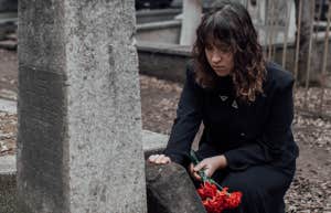 woman with roses at a grave 