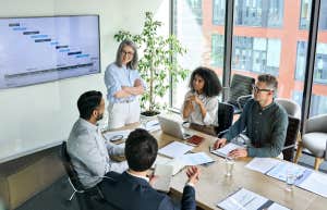 business people discussing company presentation at boardroom table.