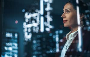 Businesswoman in Stylish Suit Working on Top Floor Office Overlooking Night City