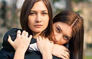photo of two sisters holding onto each other 