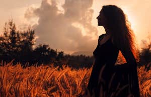 silhouette of girl in dress at sunset in field
