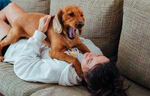 woman lying on couch with dog