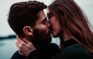 man with beard kissing woman