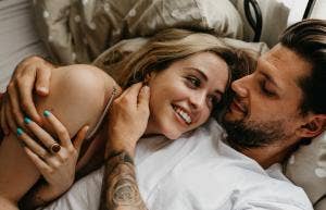 man and woman cuddling in bed