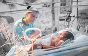 Mother looking over daughter in the NICU