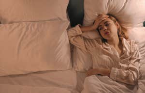 woman trying to fall asleep in bed 