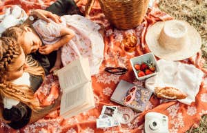Mother loving on her daughter and self, picnic and reading 