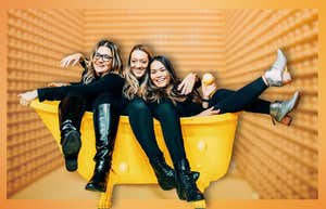 Friends laughing in a bright yellow bathtub