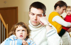 Couple with small children in a quarrel the silence and distance between them enhances the tension