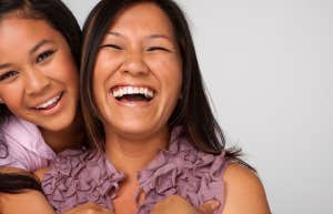 A fun loving mother and daughter share a happy moment with big smiles on their faces