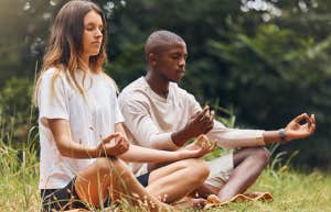 couple meditating together in grass
