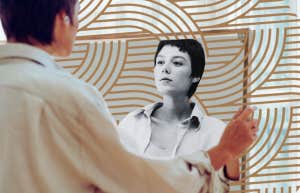 Woman looking at herself in mirror 