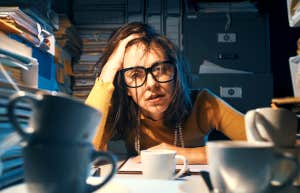 overwhelmed woman sitting at her desk