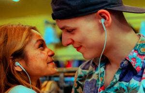couple staring into each others eyes smiling listening to music