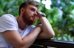 guy sitting alone outside thinking