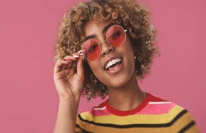 woman with rose colored glasses smiling