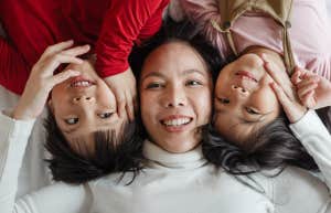 Mom and two kids lying on bed